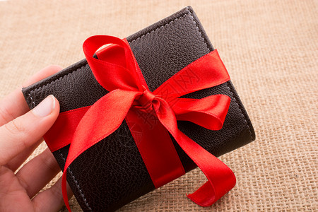 手拿着包红丝带的礼品钱包图片