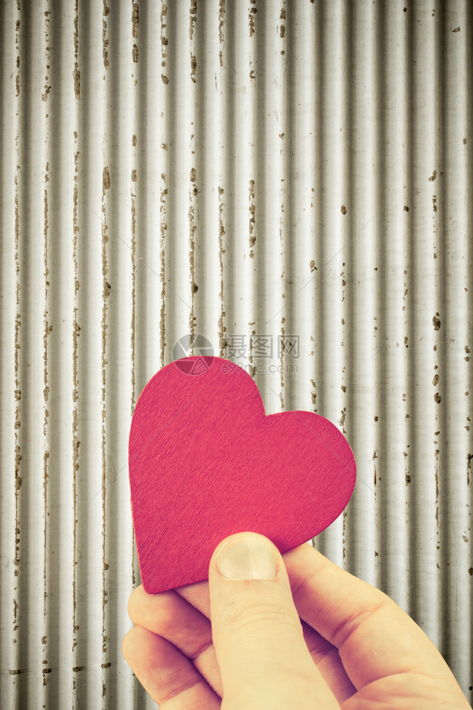 红色心形物体作为爱的概念握在手图片