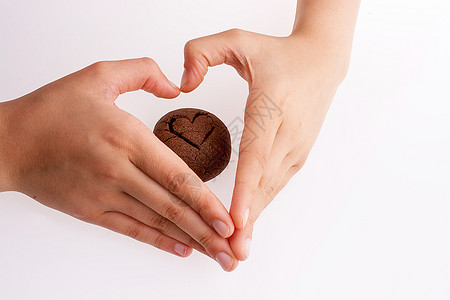 手握着心脏的白色背景巧克力饼干图片