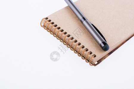 白色背景上的螺旋笔记本和授粉背景图片