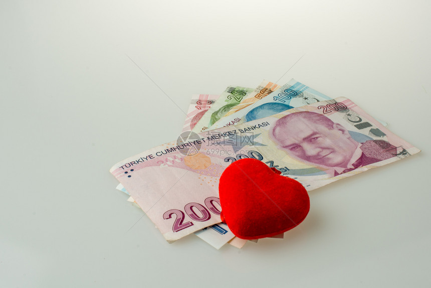白色背景红心形物体旁的土耳其里拉纸币图片