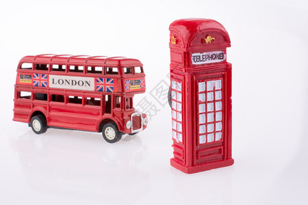 白色背景的伦敦公交车靠近一个电话亭图片