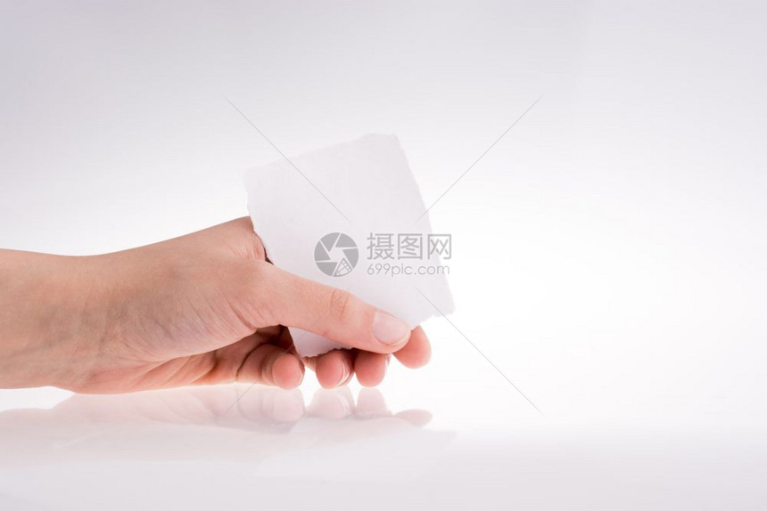 手拿着一张白背景上的撕破纸图片