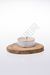 在白色背景的一块木头上放置的蜡烛背景图片