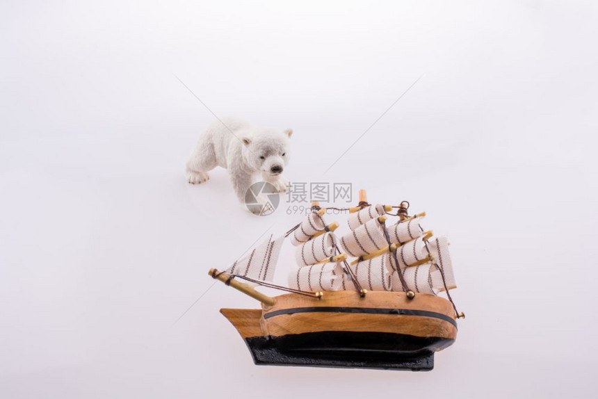 北极熊靠近一艘白色背景的老船图片