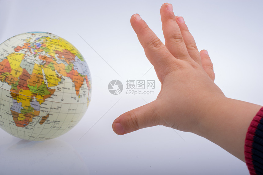 儿童在白色背景下持有一个地球图片