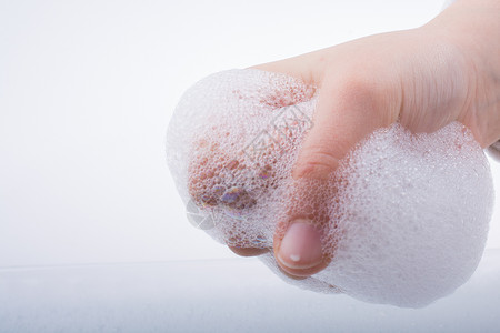 泡沫背景下的洗手和肥皂泡沫图片
