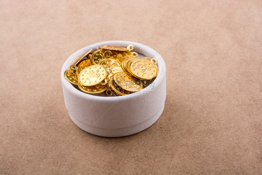 棕色背景的白盒子中假金硬币图片