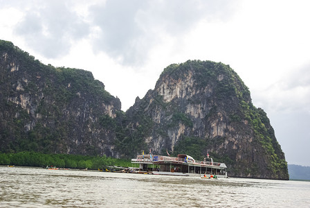 泰国普吉Phuket2014年7月3日在泰国沿海湾岩石附近水域的船图片
