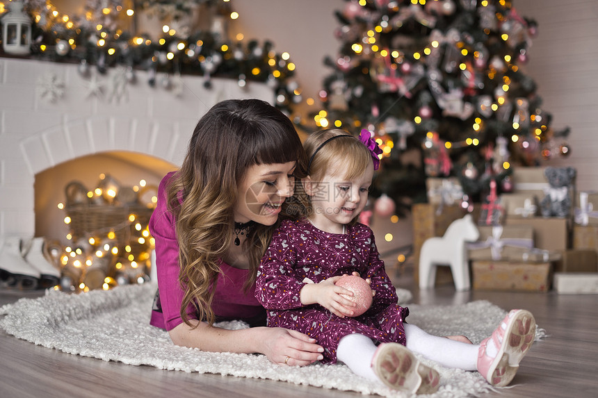 圣诞地毯下的小女孩装饰着冷杉花环坐在圣诞树旁的孩子9600图片