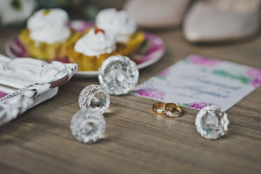 餐桌上新婚的金戒指花朵鞋子和蛋糕餐桌中间的结婚戒指装饰品963图片