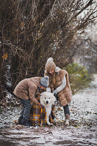 儿童与他心爱的狗一起在秋季公园散步图片