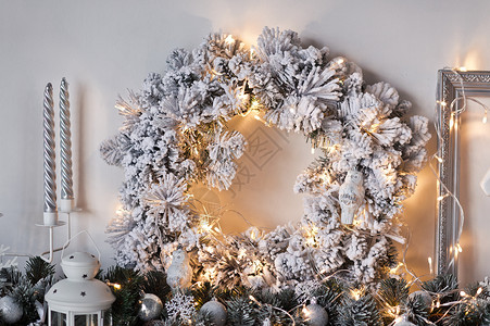 墙上装饰着白色的圣诞灯花环9326墙上壁树枝的圣诞花圈图片