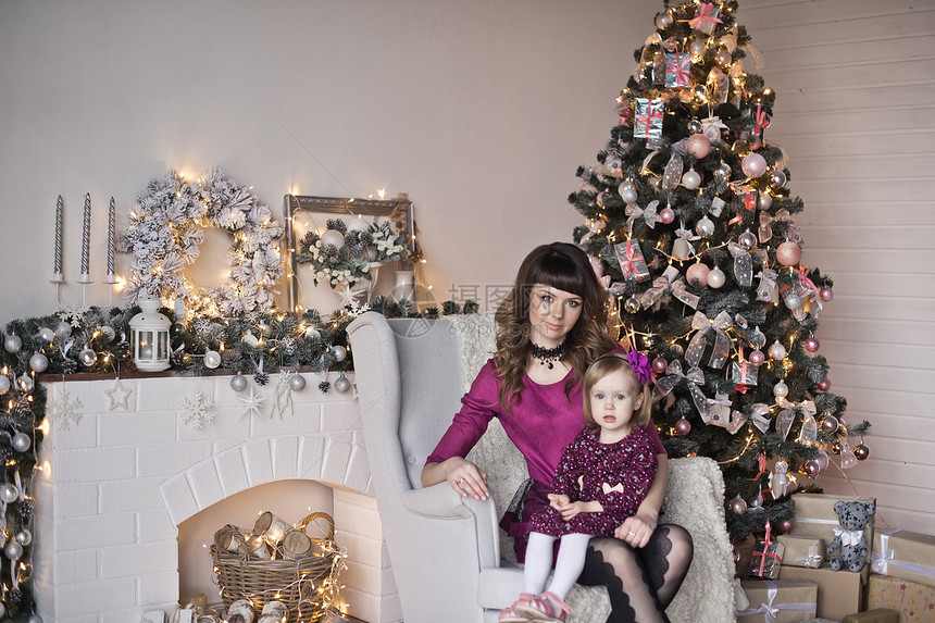 女儿和母亲坐在椅子上靠近圣诞树9631图片