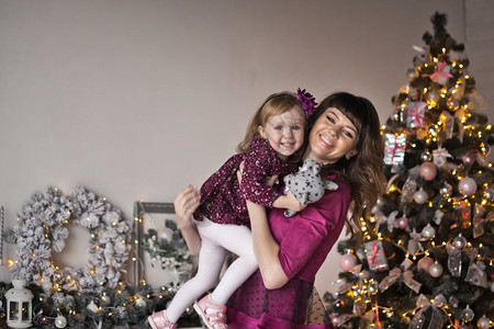 女孩和母亲穿着一件红礼服工作室背景圣诞节装饰品图片