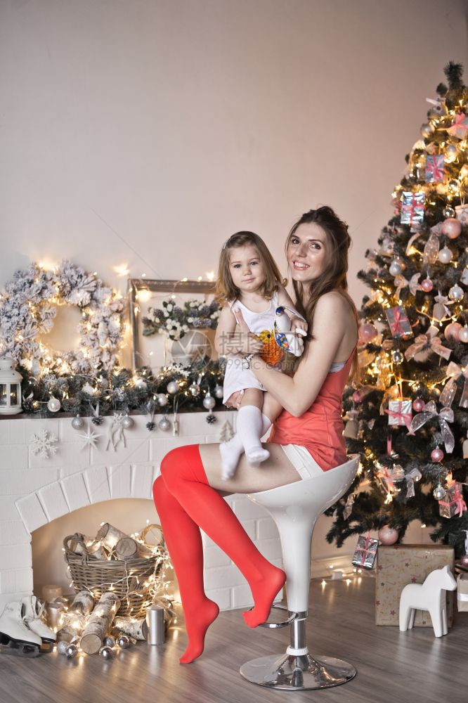 母亲和女儿在壁炉周围和圣诞节的手边图片