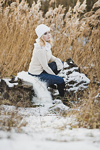 一个女孩在红雪覆盖厚的稻草中冬季画像在湖边的草原916背景图片