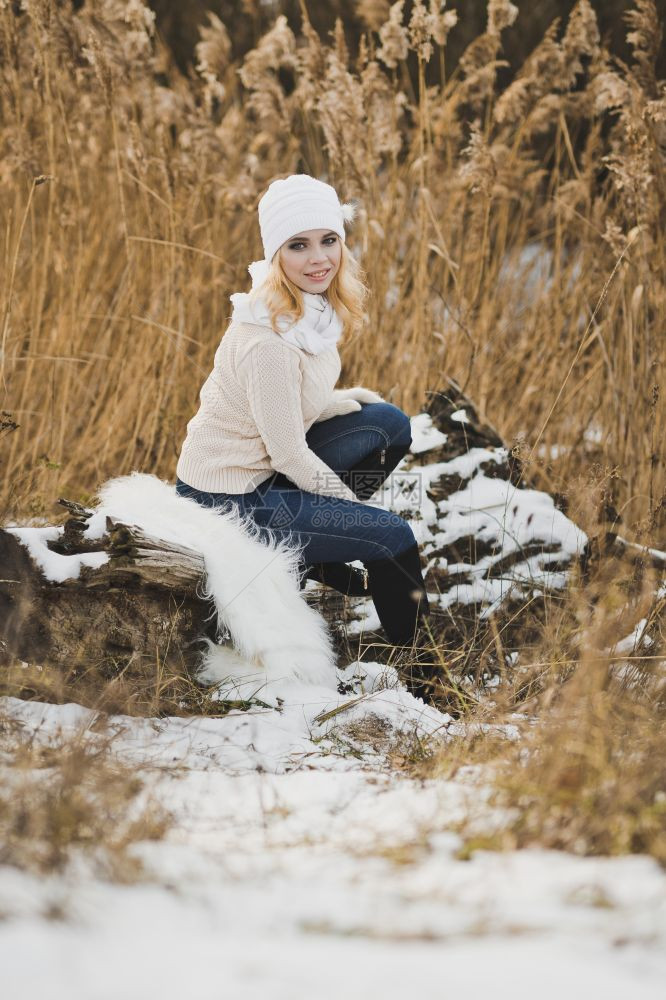一个女孩在红雪覆盖厚的草中冬季画像图片