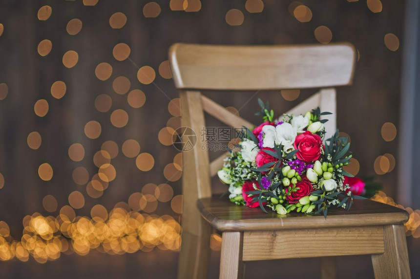 在工作室的木凳上挂着一束花朵其背景是来自8107号灯光的美丽布基图片