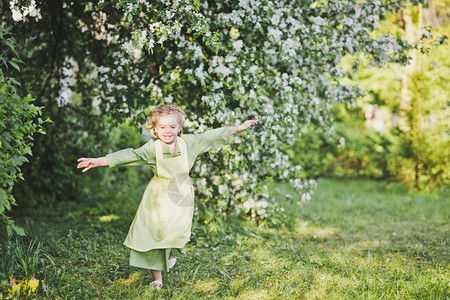 快乐的女孩在花园里跑来去一个孩子在绿色花园里跑来去8357图片