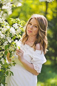 女孩敬佩樱桃园的花朵穿着白裙8234的女孩近身肖像图片