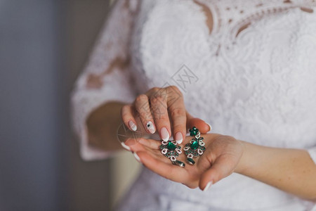 女手握着美丽的绿耳环图片
