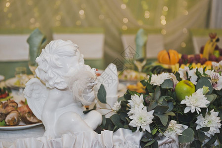 白天使在假日餐桌上的花朵中图片