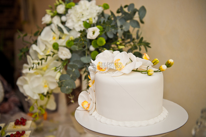 花朵在桌子上盛着甜点和蛋糕图片