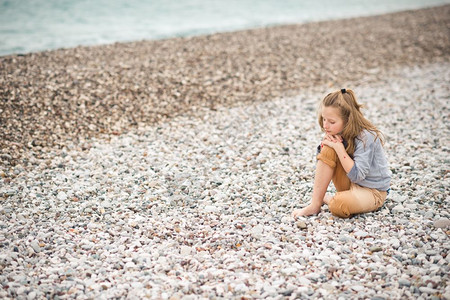 孩子坐在海滨的石上女孩躺在一个石子海滨8207图片