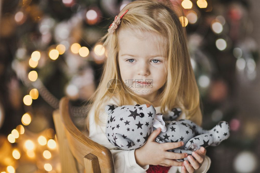 一个小女孩坐在圣诞树附近期待奇迹7318图片