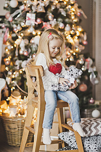 坐在圣诞树旁边的小女孩期待奇迹的到来美丽孩子期待新7309年图片