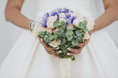 白礼服新娘手上的紫色花束白礼服新娘手里拿着一束精细的花704图片