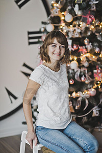 在圣诞树上穿着白色T恤的漂亮女孩肖像图片