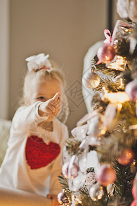 婴儿在圣诞树上玩装饰游戏孩子在圣诞节装饰上肖像728图片