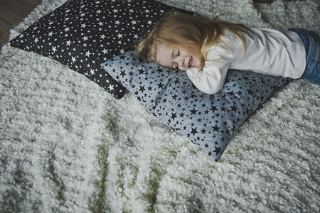 小女孩在睡梦中笑着在地毯上图片