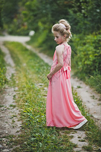 穿着长的粉红裙子女孩假扮自然背景穿着晚礼服的女孩漂亮肖像在花园650图片