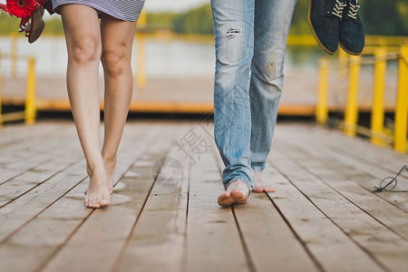 赤脚在自然界中行走公男和女的双脚在654号湖码头的足桥上图片