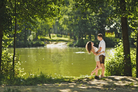快乐的情侣在湖岸边玩耍图片