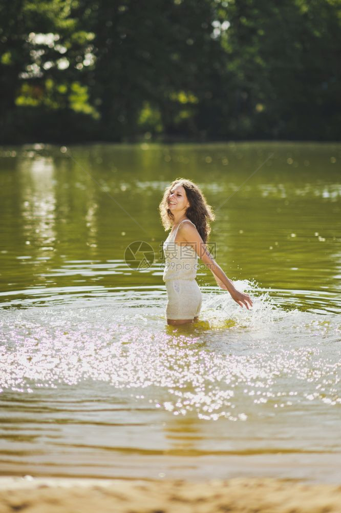 站在池塘水中的女孩肖像穿着短白色裙的女孩肖像腰部深处的水639图片
