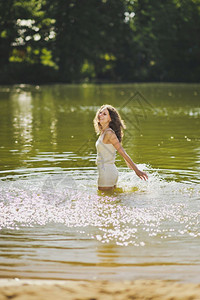站在池塘水中的女孩肖像穿着短白色裙的女孩肖像腰部深处的水639图片