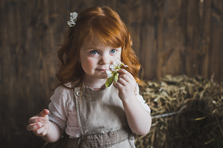 红色头发和鲜花的小女孩近距离肖像红色头发孩子的肖像白花614图片