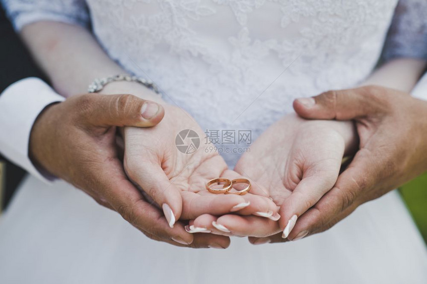 女和男手戴戒指夫妇手握的结婚戒指是6750图片