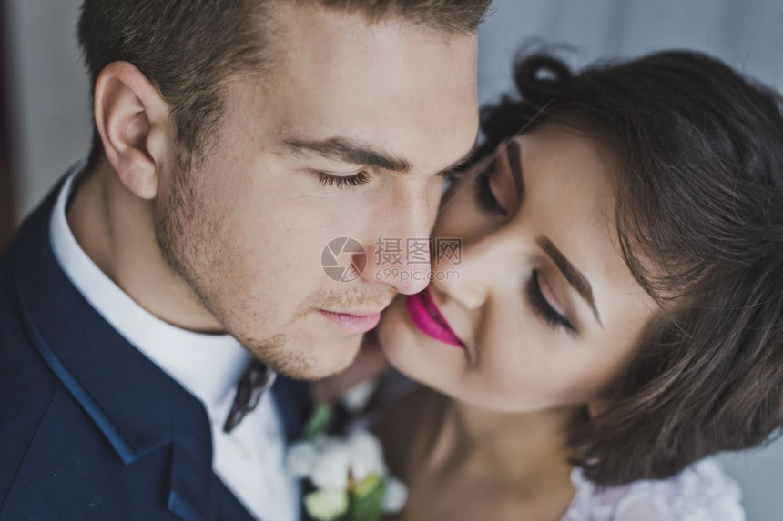 年轻的夫妻在明亮Windows642的背景中温柔地亲吻对方图片