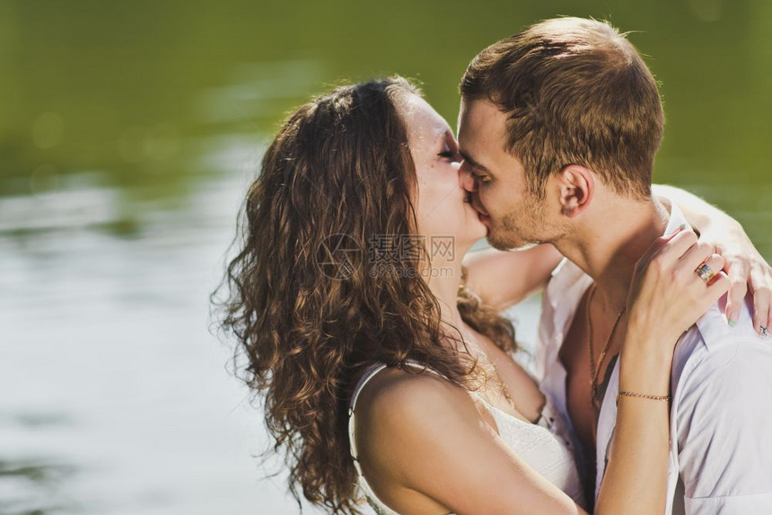 在池塘岸边亲吻年轻女孩和男人在池塘6321的水底亲吻图片
