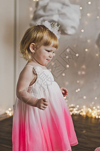 小女孩笑得很开心穿着柔软礼服的快乐孩子在背景灯5428上图片
