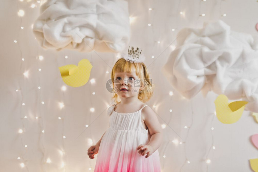 孩子戴着皇冠和粉红色的裙子小公主身处灯光和云彩的539图片