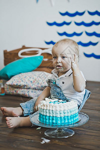 婴儿用手坐着吃蛋糕儿童把的手放在地板上5602图片
