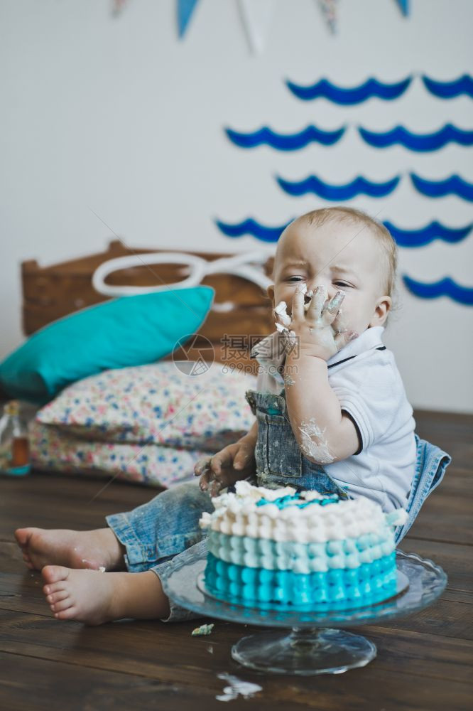 婴儿用手坐着吃蛋糕儿童把的手放在地板上5603图片