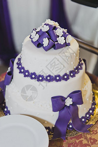 有紫色装饰品的婚礼蛋糕很棒在翅膀561等着图片