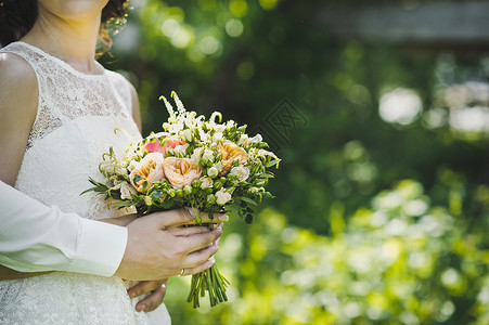 女人拿着一束玫瑰花包在新娘43手里背景图片